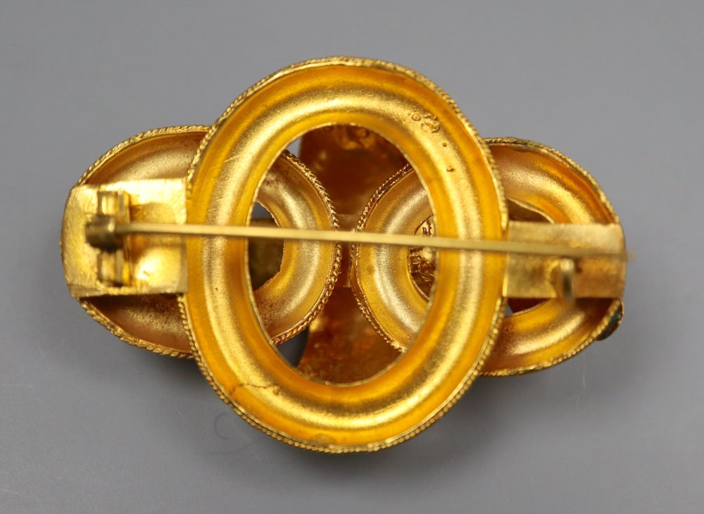 A Victorian yellow metal and seven stone garnet set scroll brooch, 47mm, gross 13.1 grams.